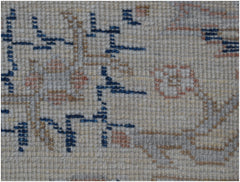 A close-up of a handmade Afghan Chobi rug featuring geometric blue patterns on a cream wool base.
