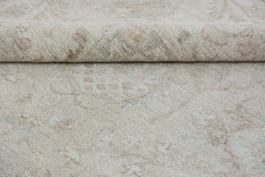 A close-up of a handmade Afghan Chobi rug featuring a neutral beige pattern on a wool pile.