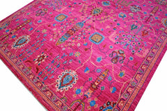 A handmade Afghan Chobi rug featuring intricate floral patterns in vibrant pink and blue tones.
