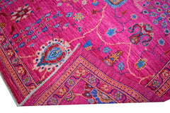 A handmade Afghan Chobi rug featuring intricate floral patterns in vibrant pink and blue tones.