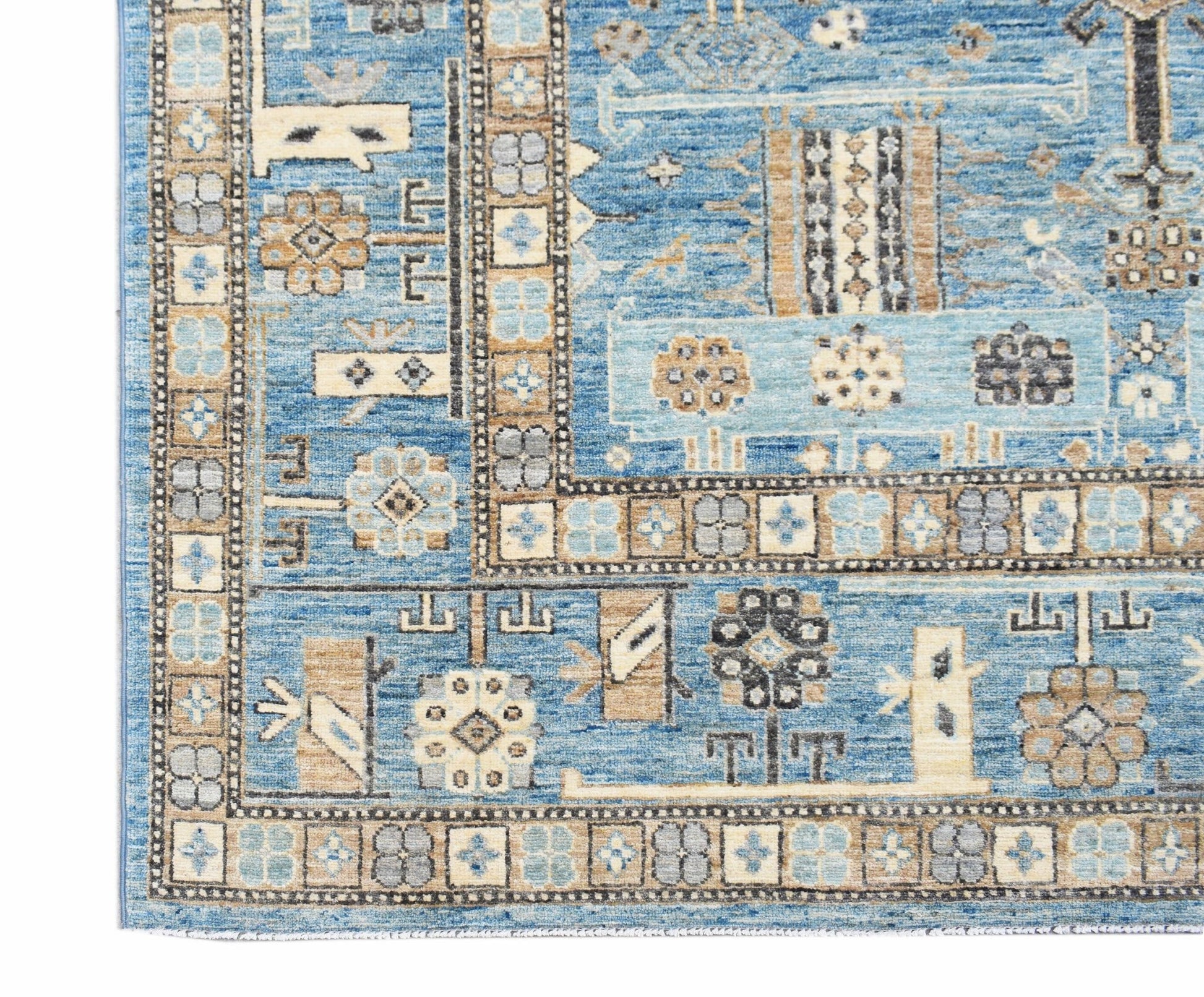 A handmade Afghan Chobi rug featuring intricate geometric patterns in shades of blue and tan.