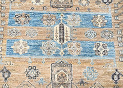 A handwoven Afghan Chobi rug featuring geometric floral motifs in blue and earthy brown tones.