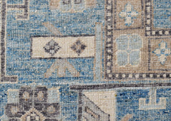 A close-up of a handwoven Afghan Chobi rug featuring geometric patterns in blue and beige tones.