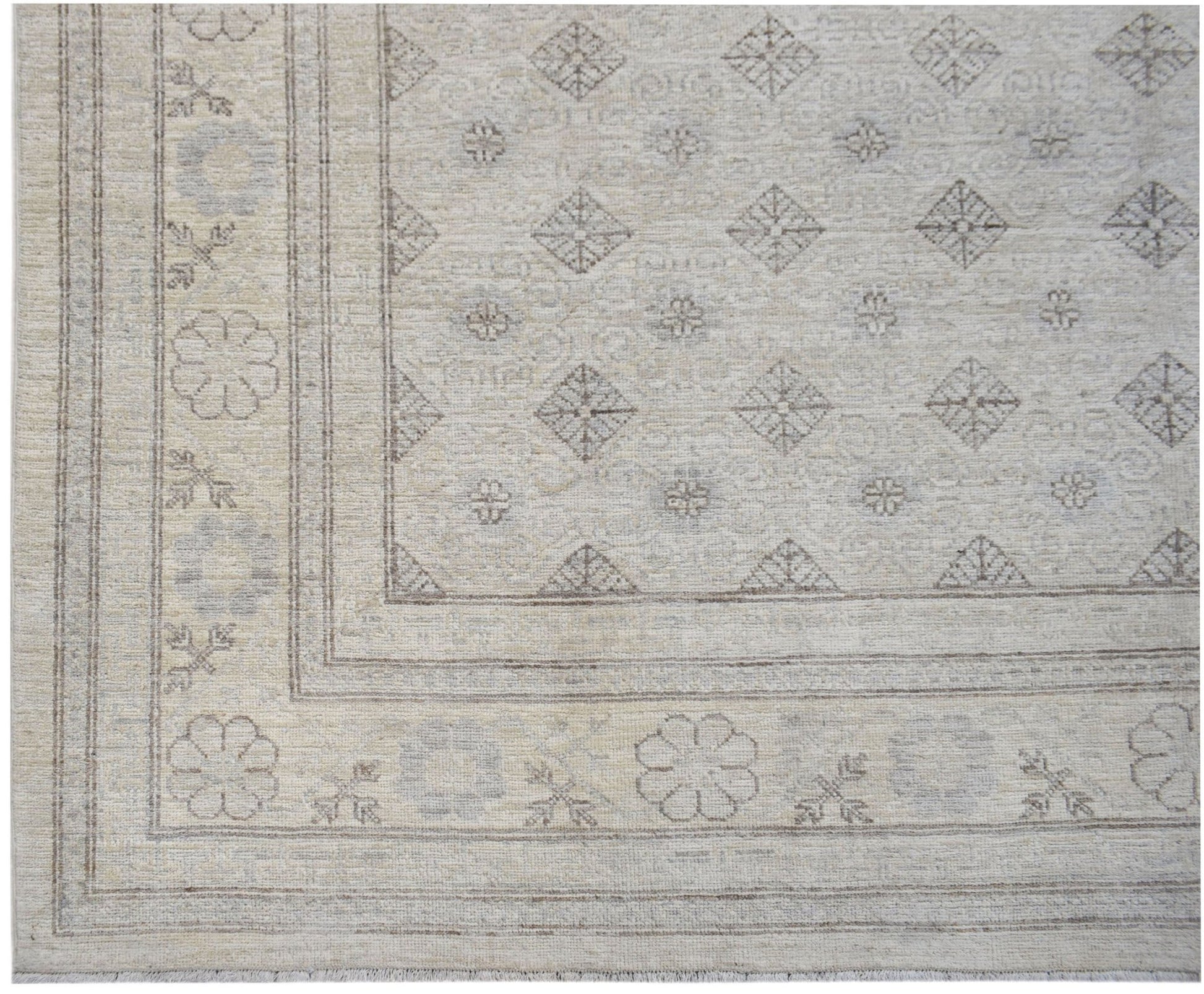 A handwoven Afghan Chobi rug featuring a neutral palette with geometric diamond and floral motifs.
