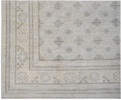 A handwoven Afghan Chobi rug featuring a neutral palette with geometric diamond and floral motifs.