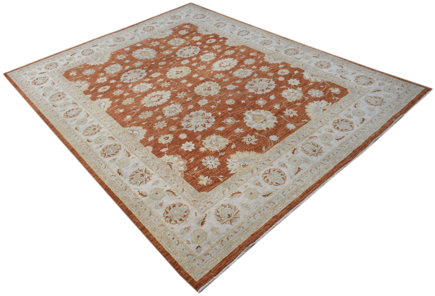 A rectangular Afghan Chobi rug featuring a floral pattern in rust orange and cream tones.