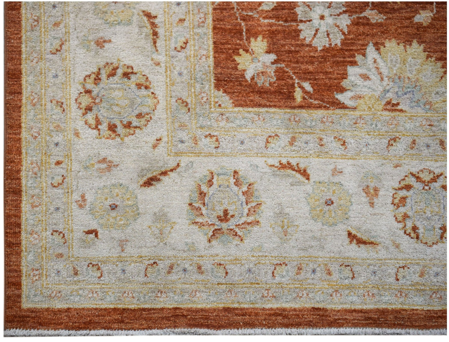 A handmade Afghan Chobi rug featuring a traditional floral pattern in rust and cream tones.