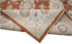 A handmade Afghan Chobi rug featuring a traditional floral pattern in rust and cream tones.