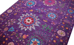 A handwoven Afghan Chobi rug featuring a vibrant purple field with colorful floral medallions.