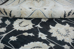 A handmade Afghan Chobi rug featuring a dark floral pattern with a folded corner showing the back.