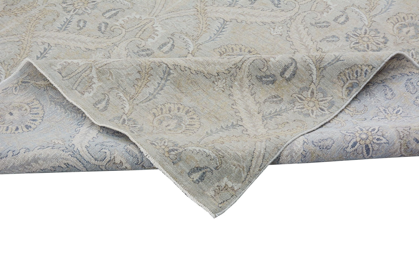A handmade Afghan Chobi rug featuring a traditional floral pattern in muted beige and blue tones.