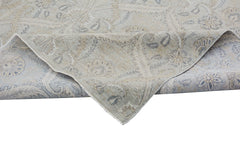 A handmade Afghan Chobi rug featuring a traditional floral pattern in muted beige and blue tones.