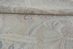 A handmade Afghan Chobi rug featuring a traditional floral pattern in neutral beige and grey tones.