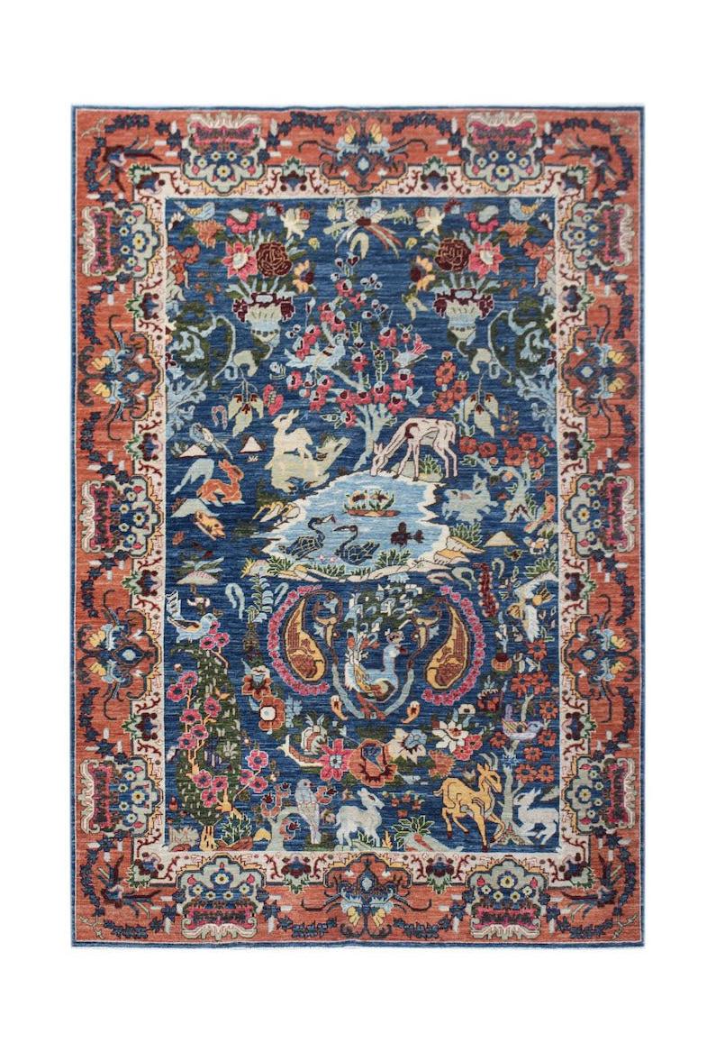 A rectangular Afghan Chobi rug featuring a blue field with intricate floral and animal motifs.