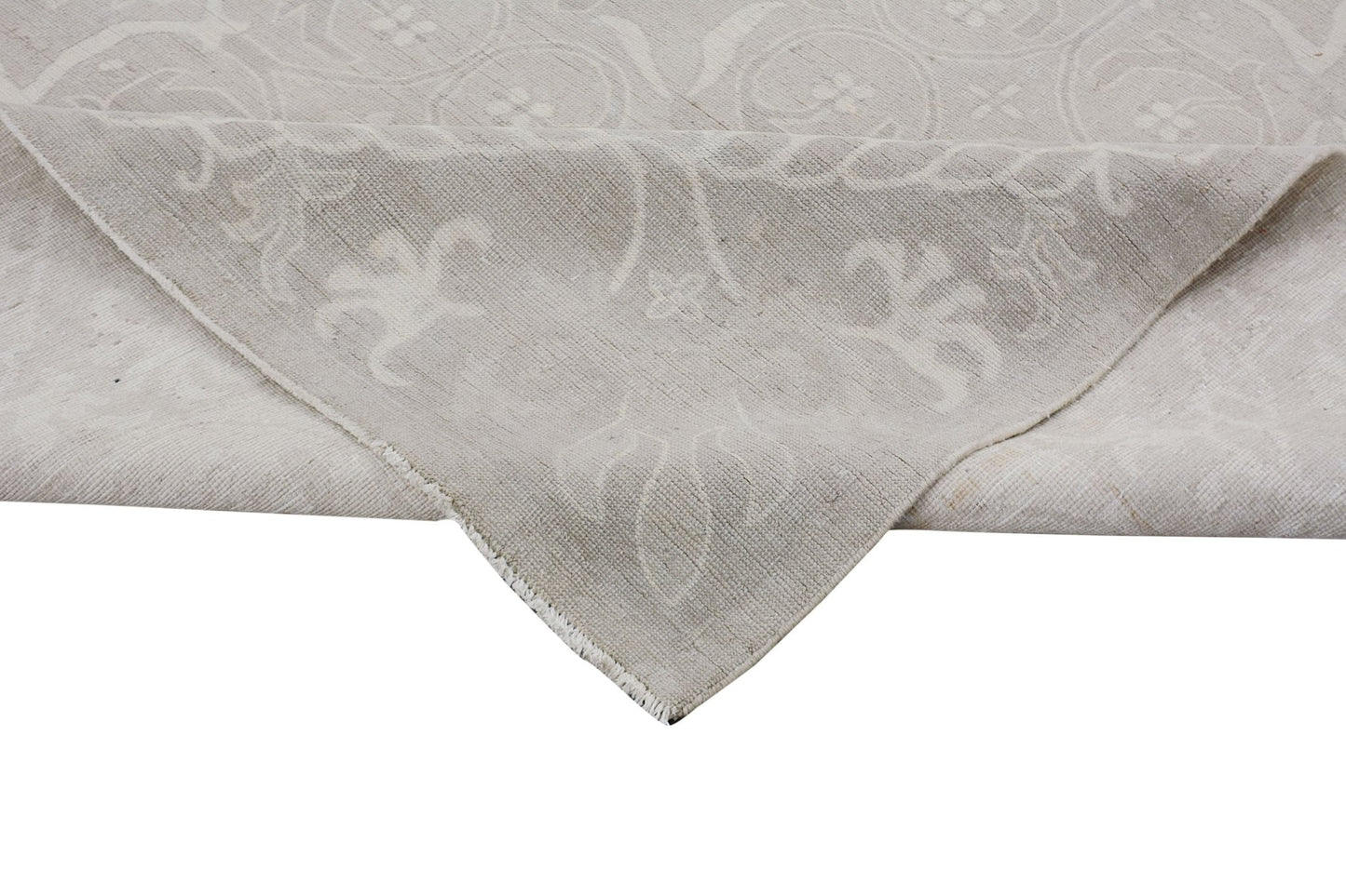 A handmade Afghan Chobi rug featuring a neutral, monochromatic floral pattern on handspun wool.
