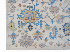 Handwoven Afghan Chobi rug featuring a traditional floral pattern in blue, yellow, and soft purple.