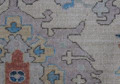 A close-up of a handwoven Afghan Chobi rug featuring traditional geometric patterns in muted tones.