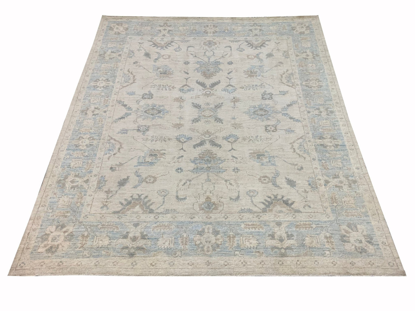 An Afghan Chobi rug featuring a traditional floral pattern in soft blue and beige tones.