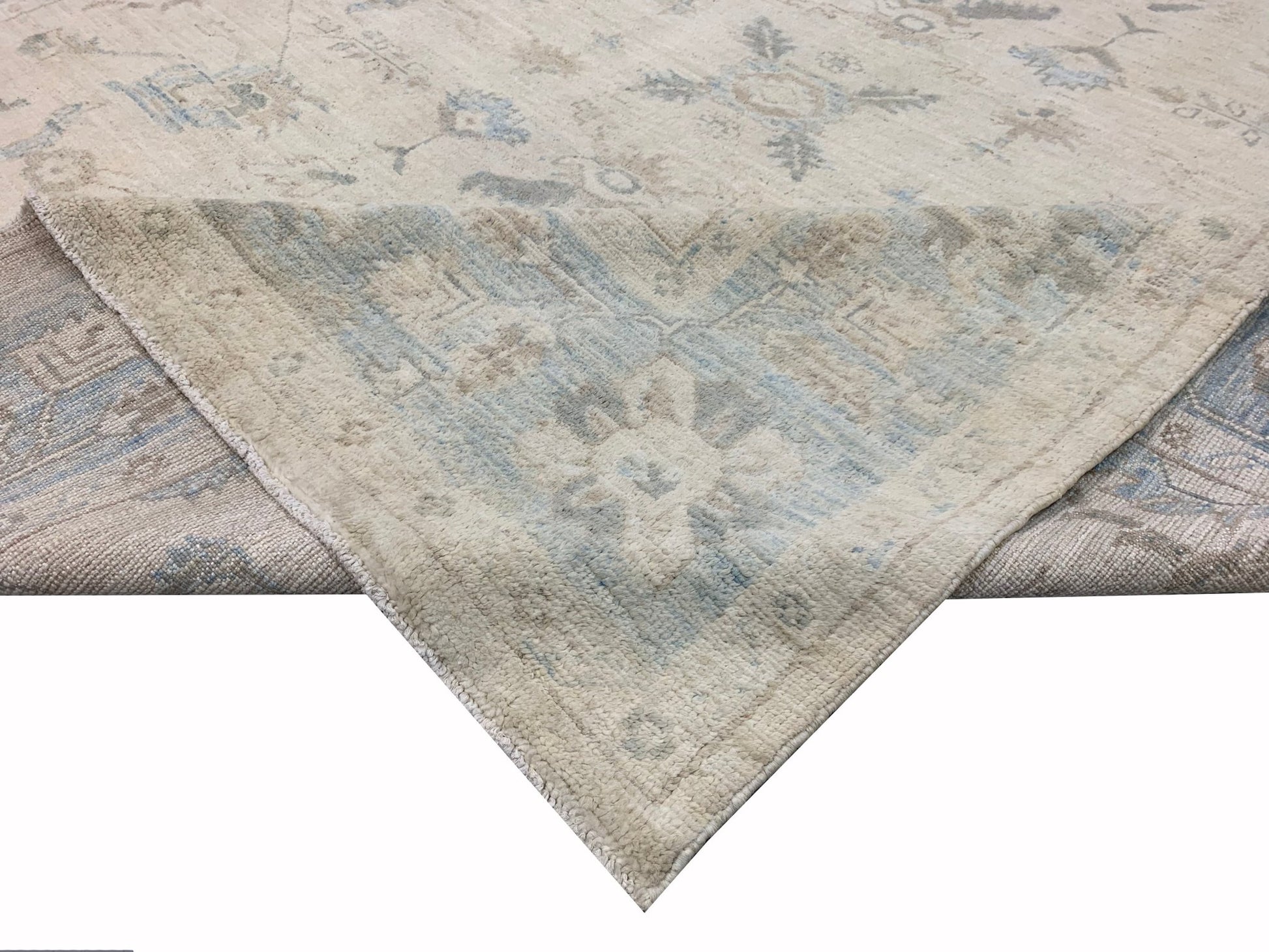 A handmade Afghan Chobi rug featuring a traditional floral pattern in soft blue and beige tones.