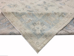 A handmade Afghan Chobi rug featuring a traditional floral pattern in soft blue and beige tones.