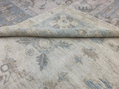 A handmade Afghan Chobi rug featuring a traditional floral pattern in soft blue and beige tones.