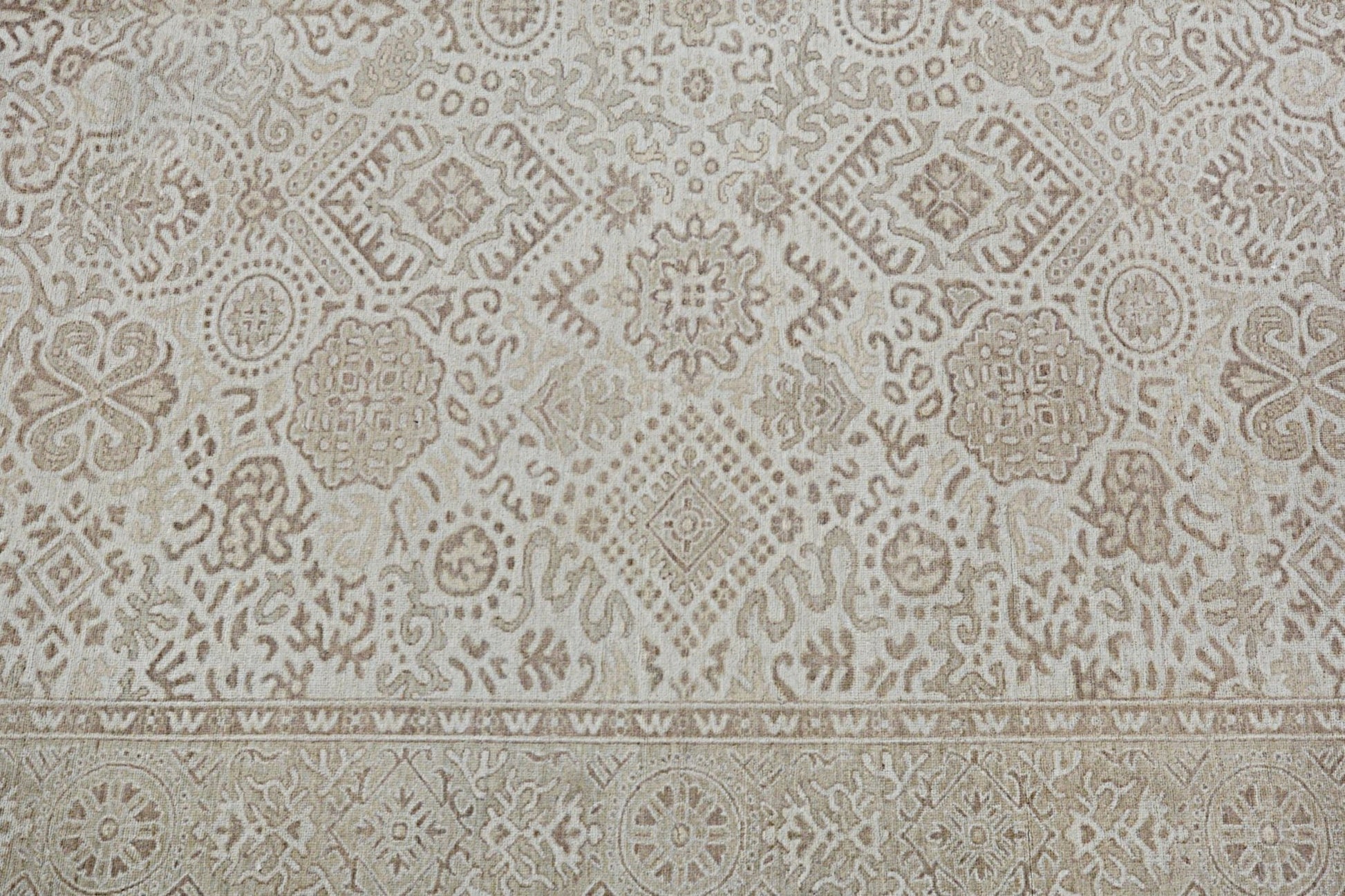 A handmade Afghan Chobi rug featuring a traditional beige and brown geometric floral pattern.