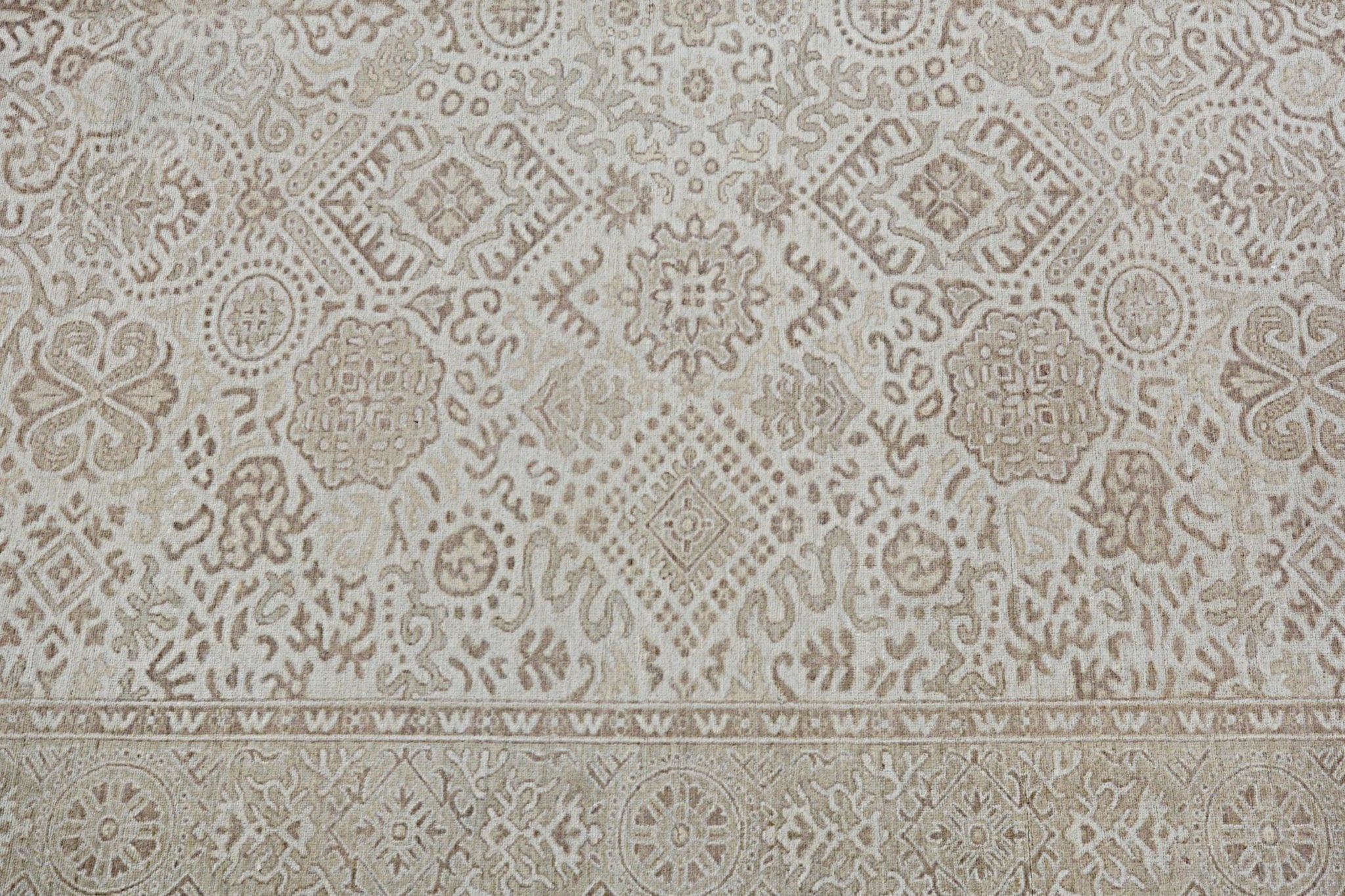 A handmade Afghan Chobi rug featuring a traditional beige and brown geometric floral pattern.