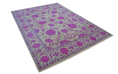 A rectangular Afghan Chobi rug featuring a vibrant magenta floral pattern on a light grey field.