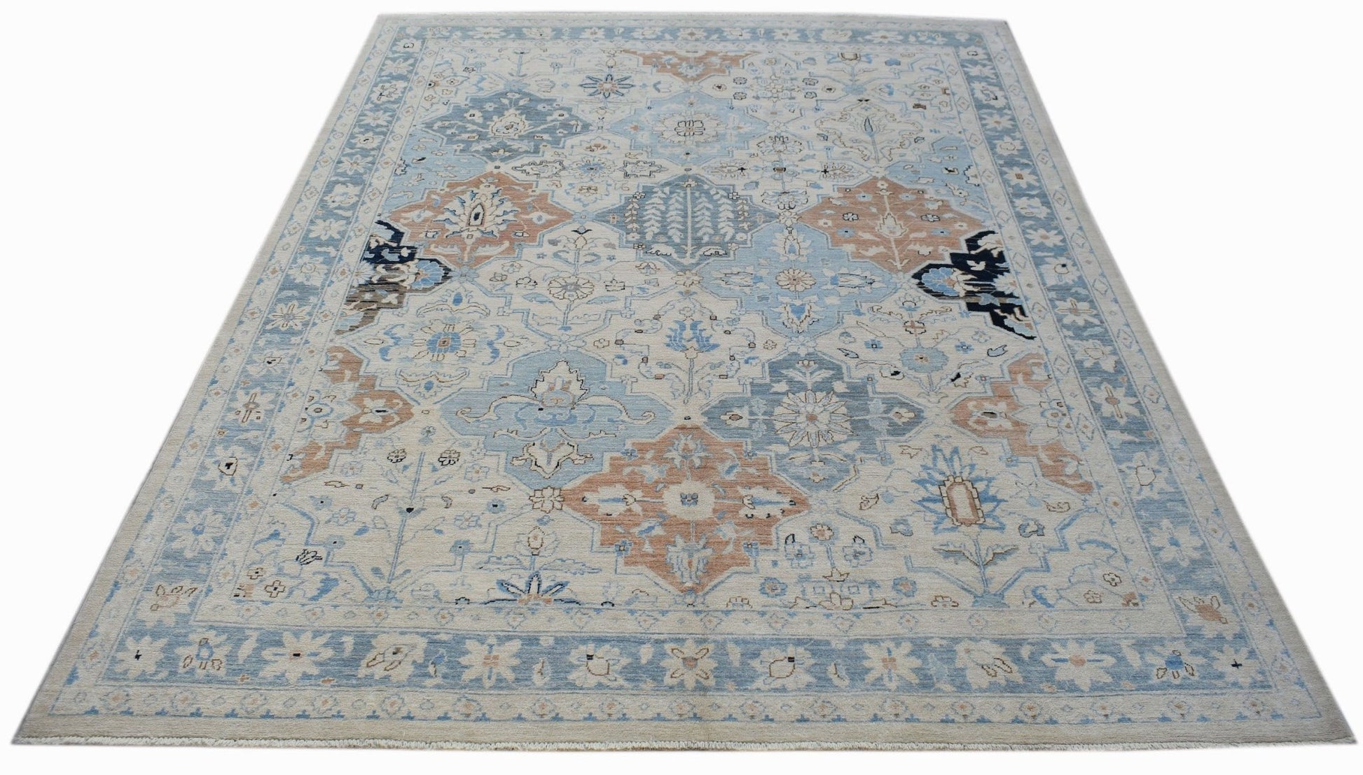 A handmade Afghan Chobi rug featuring a traditional floral pattern in shades of blue and tan.