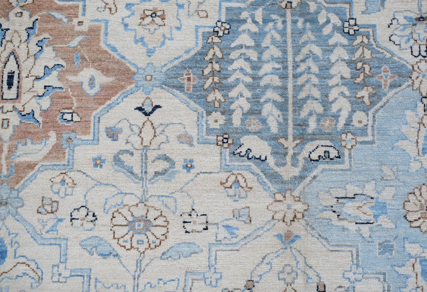 A handwoven Afghan Chobi rug featuring a traditional floral pattern in shades of blue and tan.