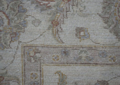 A close-up of a handwoven Afghan Chobi rug featuring traditional floral patterns in muted tones.