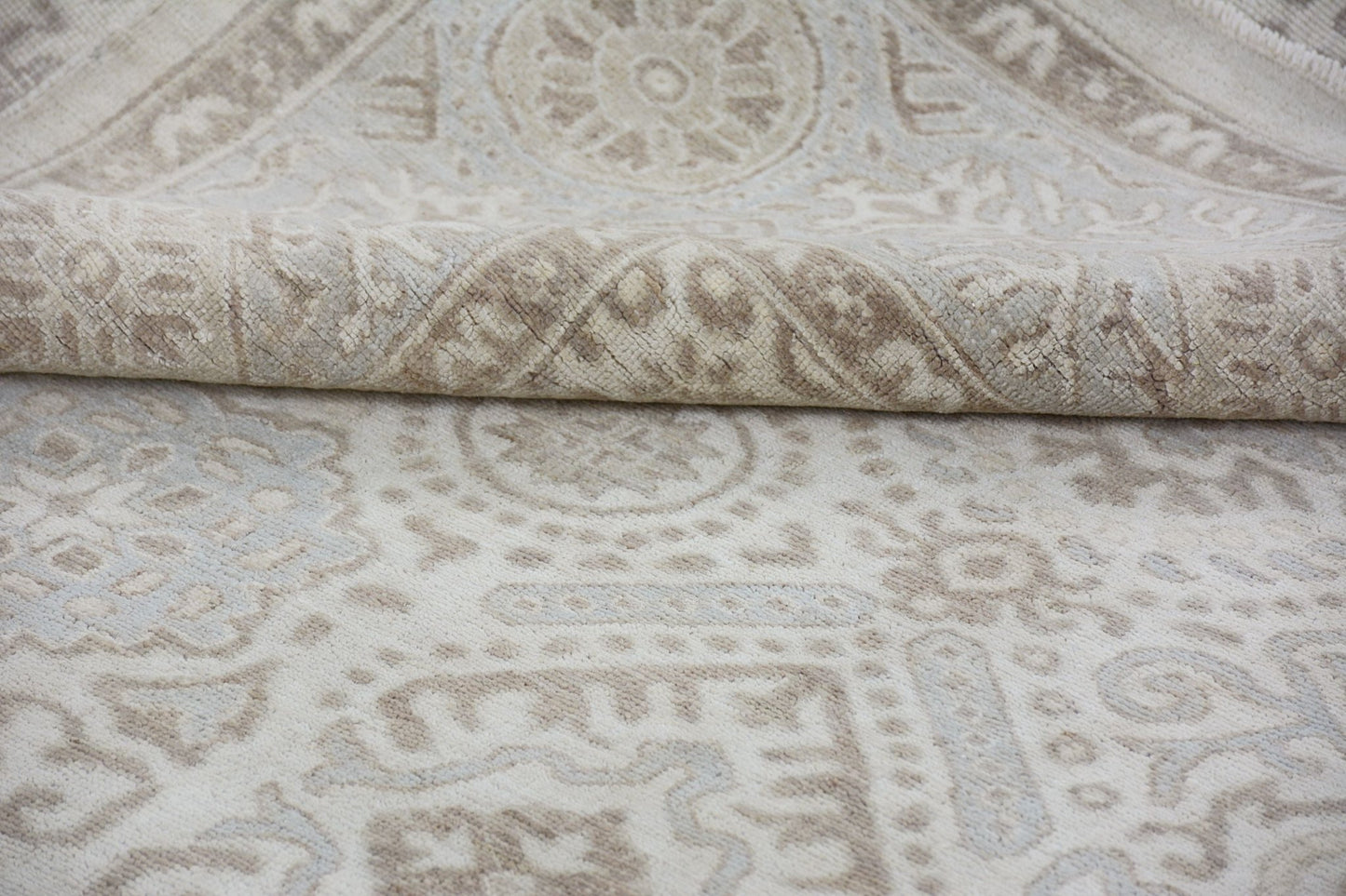 A handmade Afghan Chobi rug featuring a traditional beige and cream geometric pattern.