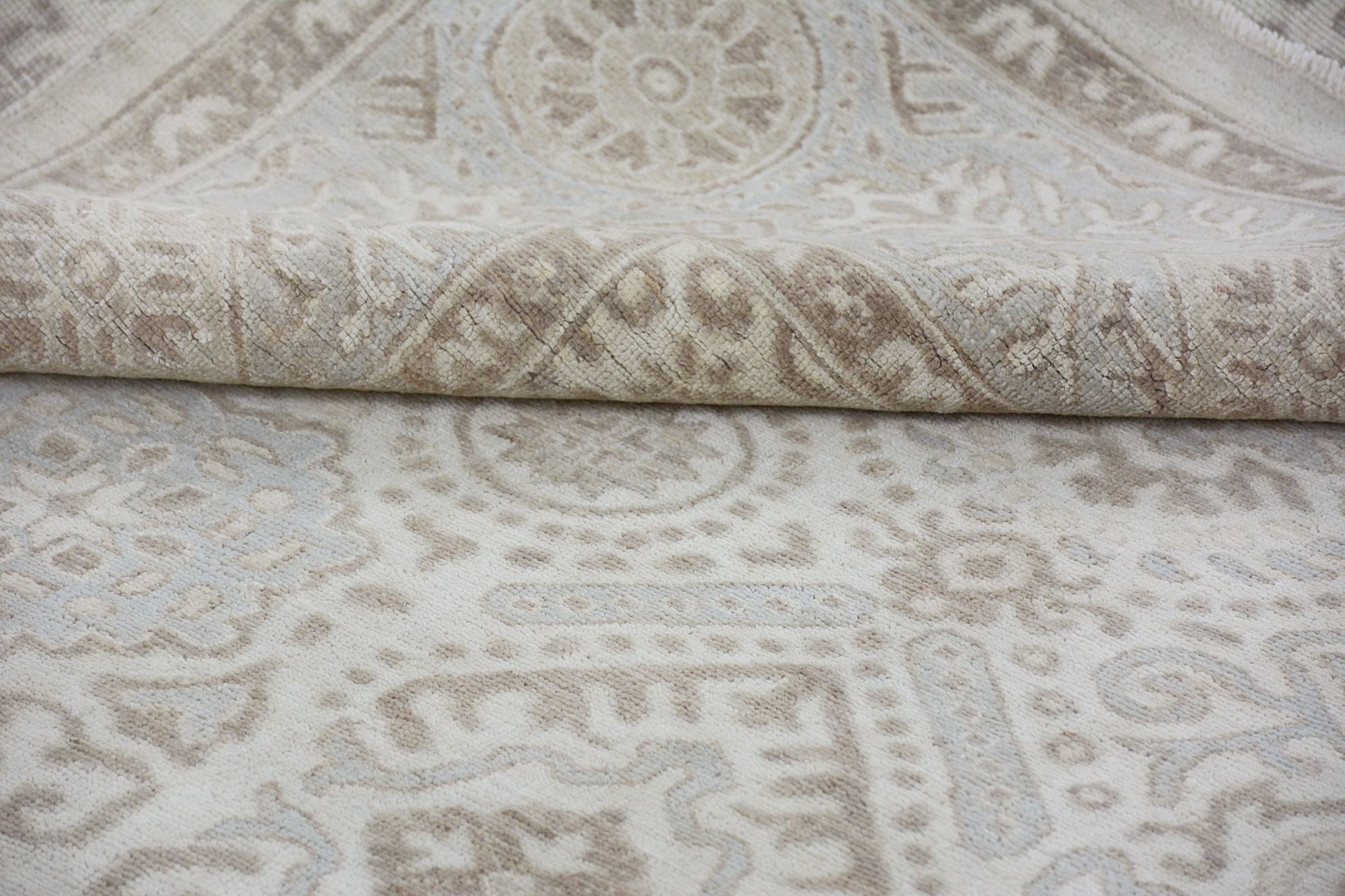 A handmade Afghan Chobi rug featuring a traditional beige and cream geometric pattern.