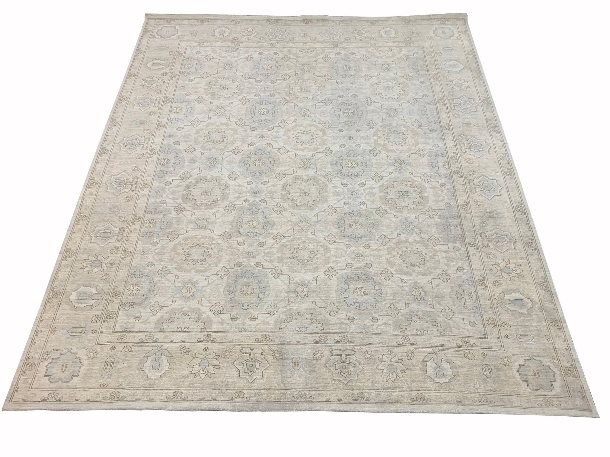 A handmade Afghan Chobi rug featuring a traditional floral pattern in soft beige and blue tones.