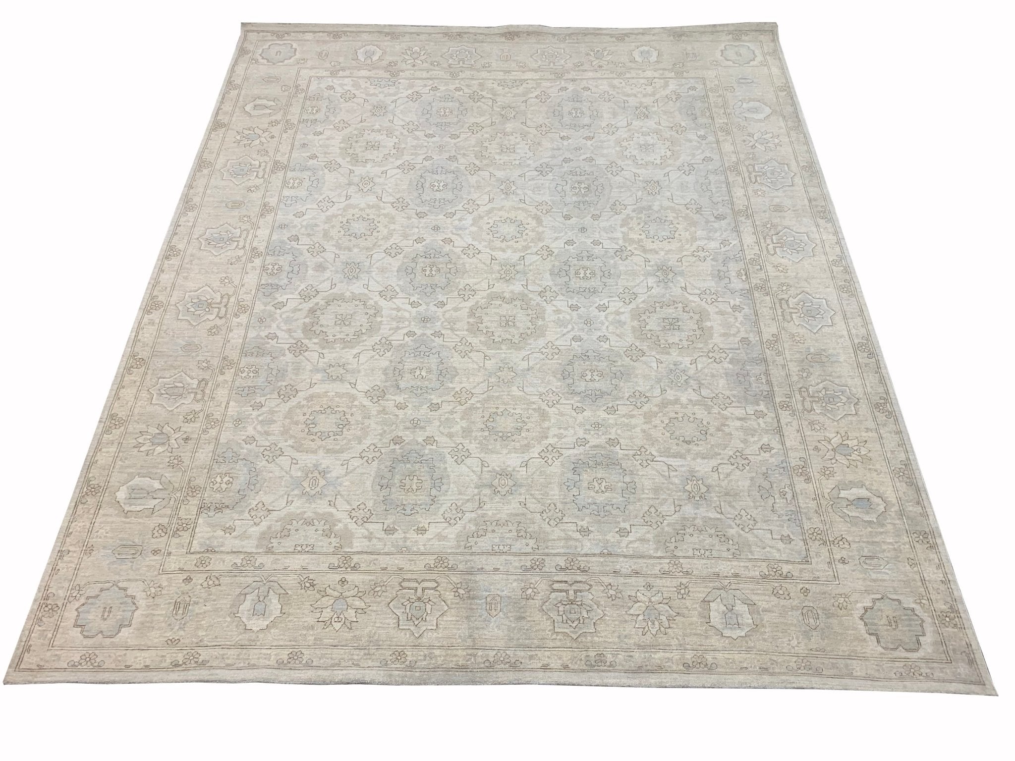 A handmade Afghan Chobi rug featuring a traditional floral pattern in soft beige and blue tones.