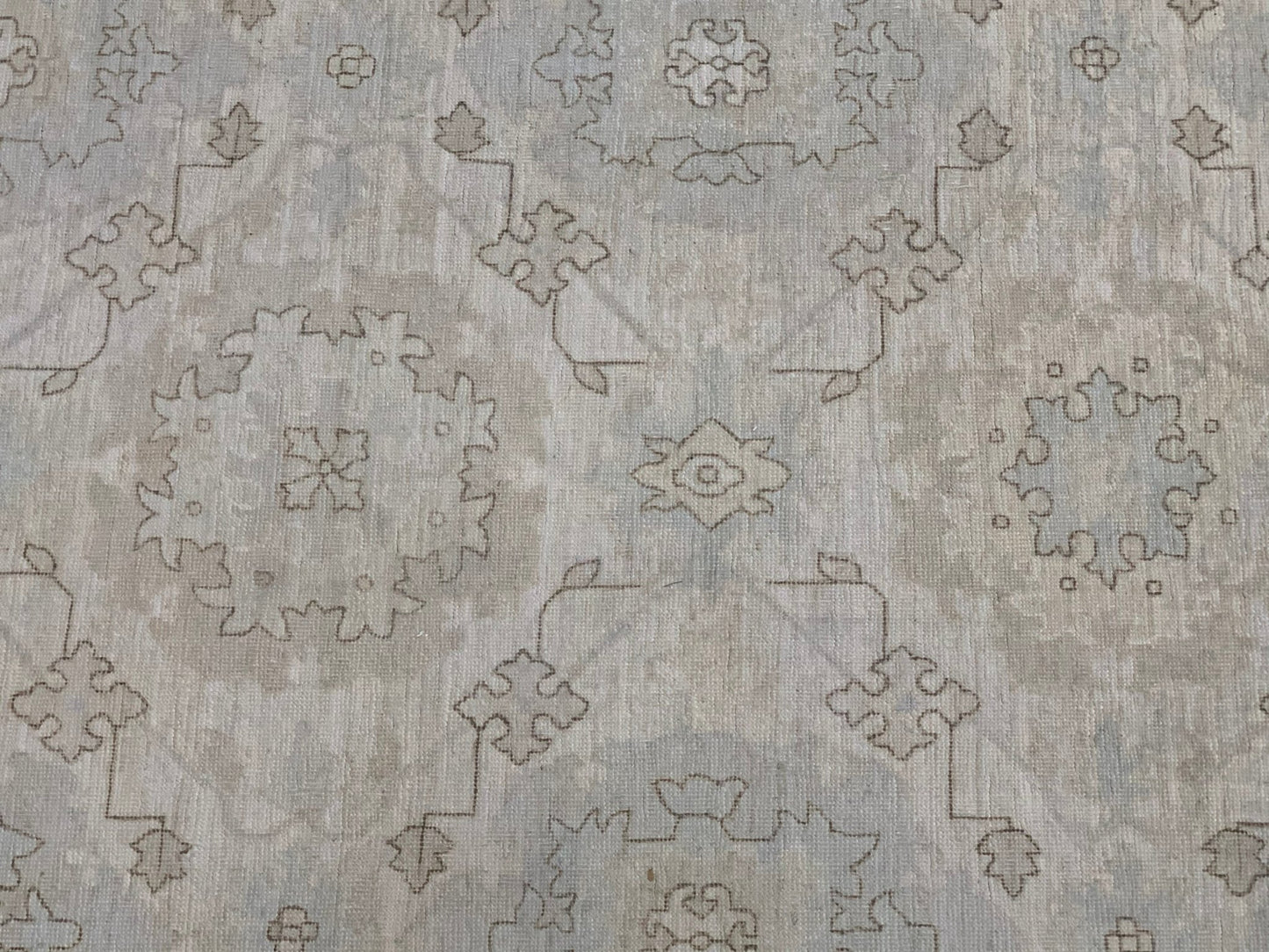 An Afghan Chobi rug featuring a traditional geometric floral pattern in soft neutral tones.