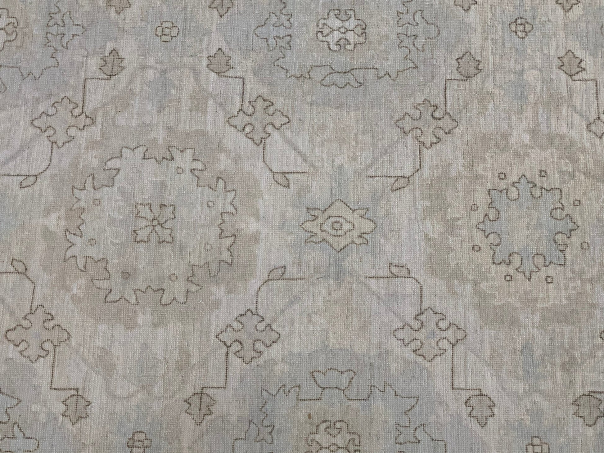 An Afghan Chobi rug featuring a traditional geometric floral pattern in soft neutral tones.
