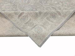 A handmade Afghan Chobi rug with a traditional floral pattern in muted beige and blue tones.
