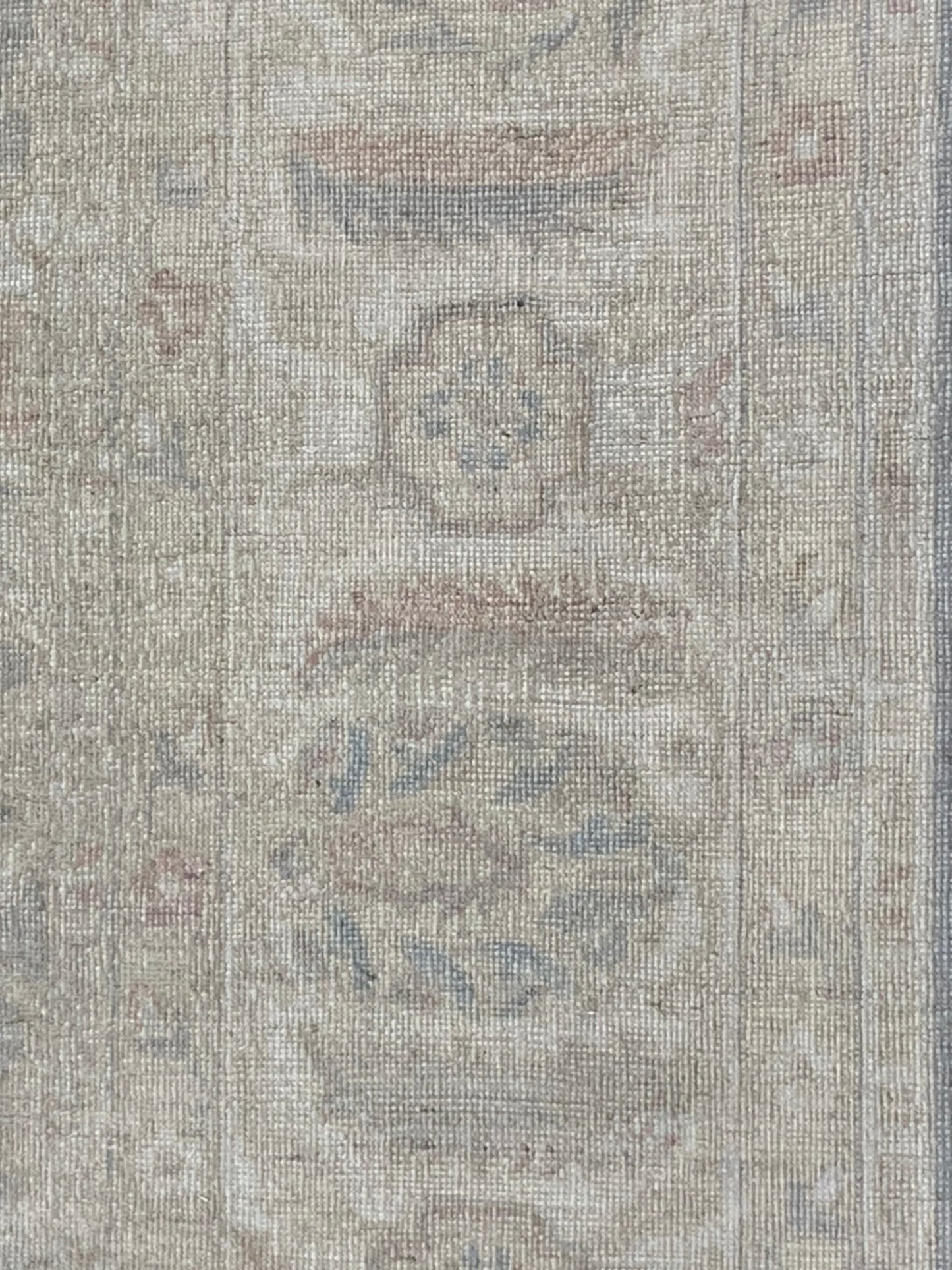 A handmade Afghan Chobi rug featuring traditional floral patterns in soft, neutral wood tones.