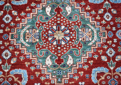 A handmade Afghan Chobi rug featuring a traditional geometric floral pattern in red and teal.