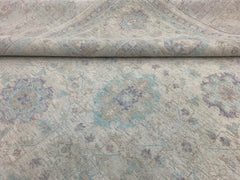 A handmade Afghan Chobi rug featuring a traditional floral pattern in soft blue and beige tones.