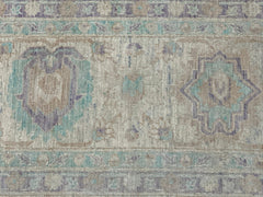 A handmade Afghan Chobi rug featuring traditional geometric patterns in muted blue and beige tones.