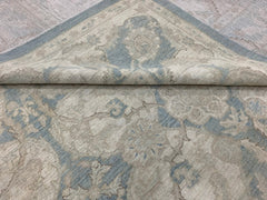 A handmade Afghan Chobi rug featuring a traditional floral pattern in soft blue and beige tones.