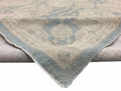 A handmade Afghan Chobi rug featuring a traditional floral pattern in soft blue and beige tones.