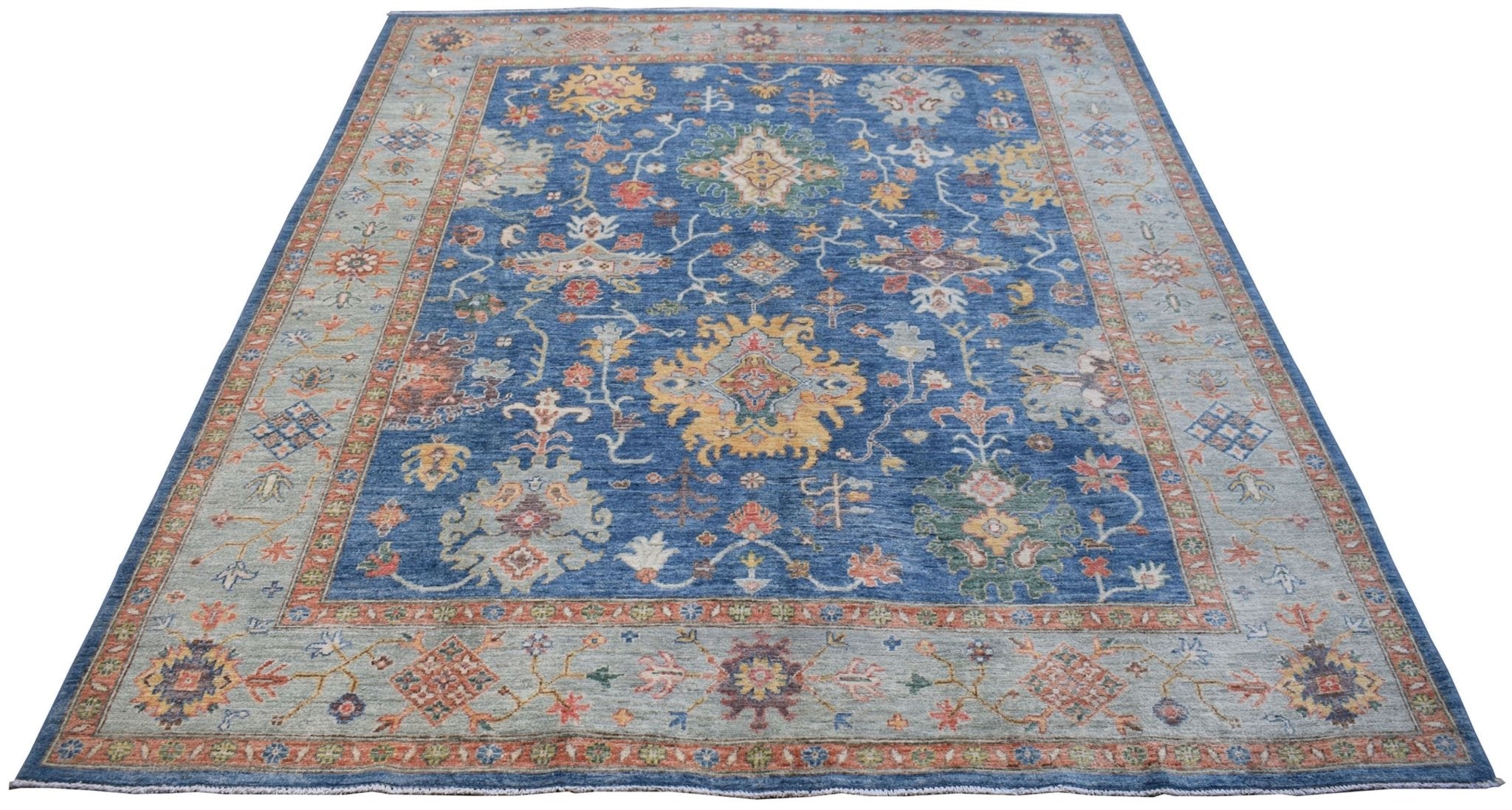 A handmade Afghan Chobi rug featuring a traditional floral pattern in blue and earthy tones.