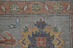 A close-up of a handmade Afghan Chobi rug featuring intricate floral patterns in earthy tones.