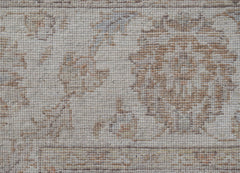 A close-up of a handwoven Afghan Chobi rug featuring a traditional floral pattern in neutral tones.