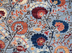 Handwoven Afghan Chobi rug featuring a floral pattern in shades of blue, red, and cream.