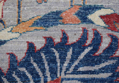A close-up view of a handwoven Afghan Chobi rug featuring intricate blue and red floral patterns.