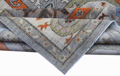 A folded Afghan Chobi rug featuring traditional patterns in shades of grey, orange, and green.